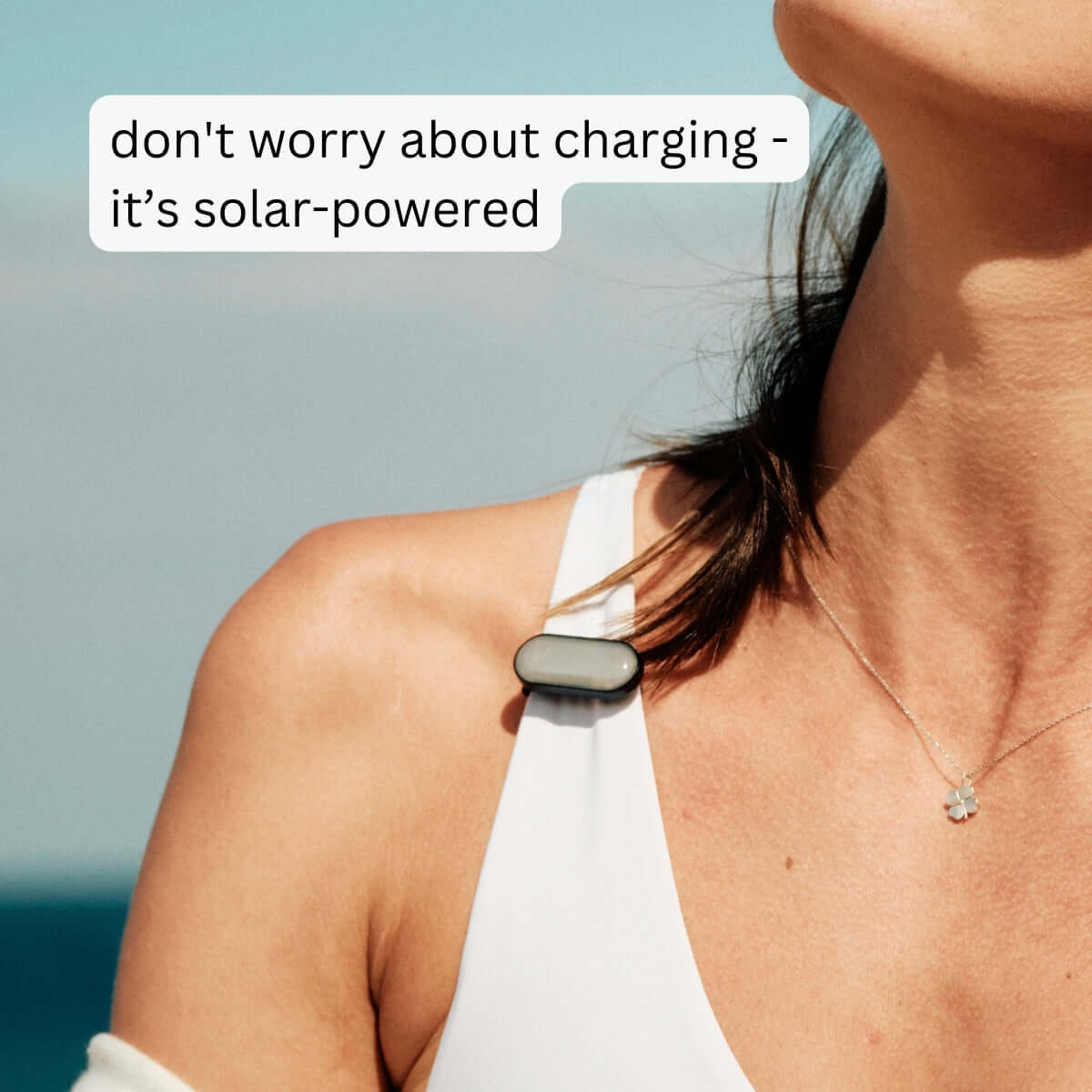 Woman with sun-a-wear UV tracker attached to her tank top strap, don't worry about charging - it's solar-powered