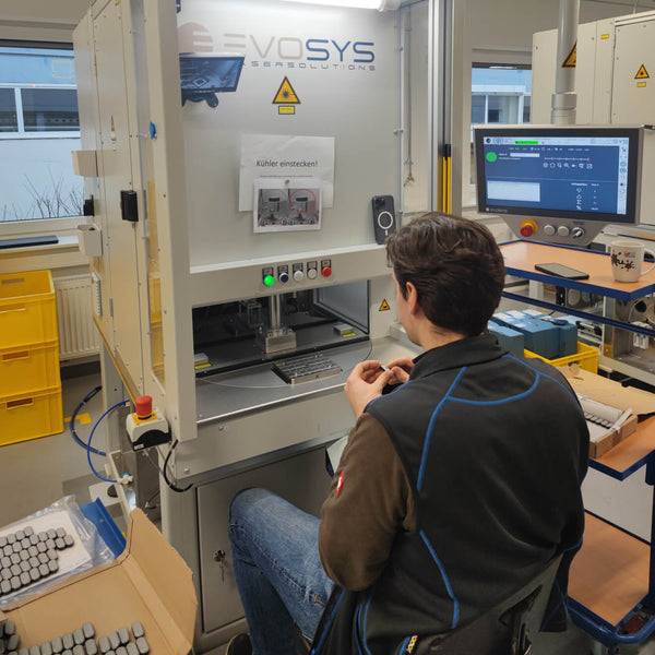 Man sitting next to hi-tech machine showing production of sun-a-wear UV tracker