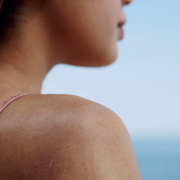 Close up of slightly sunburned woman's shoulder exposed skin