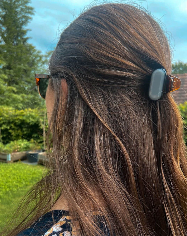 Woman ingeniously wearing sun-a-wear UV tracker as a hair clip