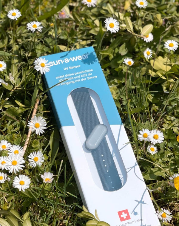 sun-a-wear UV tracker packaging on flowery grass